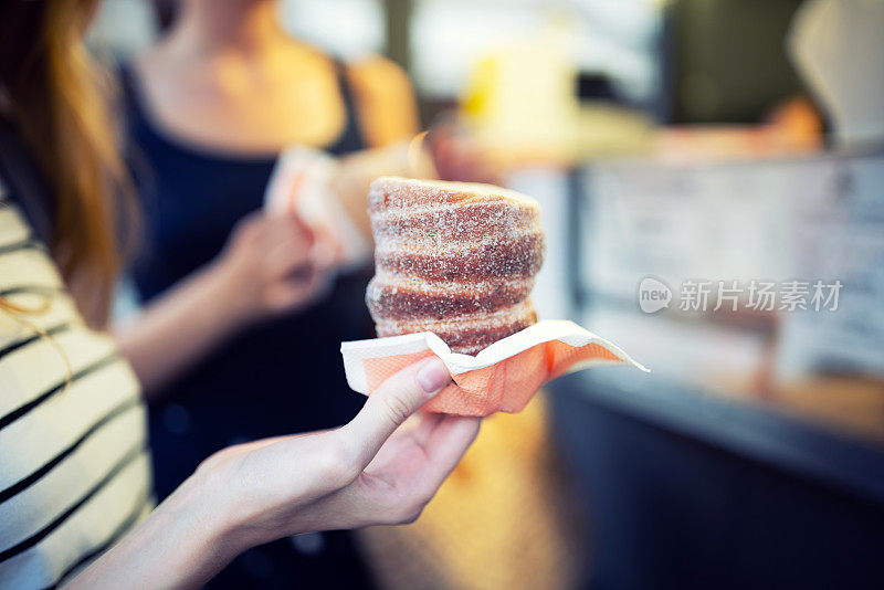 手握烤制trdelnik -美味的烘焙糕点食品